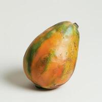 A ripe pear with a colorful transition from green to orange, sitting on a white surface. photo