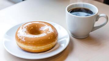 A donut and a cup of coffee on a table photo
