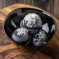 Black ice cream with coconut flakes in a bowl photo
