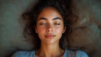 A woman with long hair is sleeping on a couch. She has a beautiful face with a nice smile photo