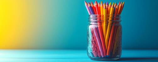 A jar full of colored pencils on a table. The jar is full of pencils of different colors, including red, yellow, and blue. The pencils are arranged in a way that they are all visible and easy to see photo