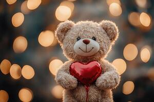 Teddy bear holding red heart with romantic bokeh lights background photo