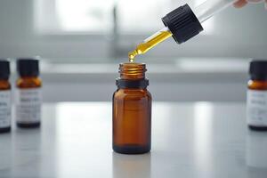 Scientist dropping cbd oil into a small brown bottle using a dropper photo