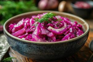 Braised red cabbage garnished with fresh dill in rustic bowl photo