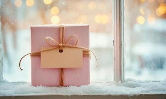 A pink box with a brown ribbon and a tag on it photo