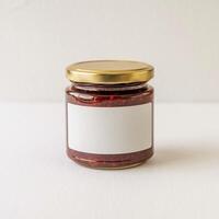 Glass jar with red preserve, blank label, golden lid, on white background For Social Media Post Size photo
