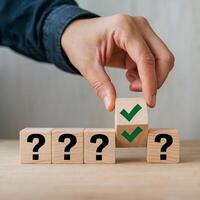 Hand selects wooden block with green checkmark from row of question marked blocks For Social Media Post Size photo