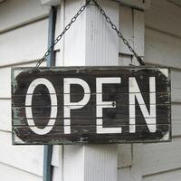 Weathered wooden signboard with OPEN written in white letters on white wall For Social Media Post Size photo