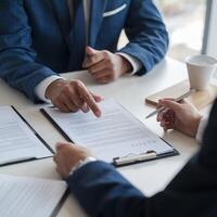 Professional setting, person in blue suit points to contract, creating focused ambiance For Social Media Post Size photo