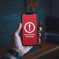 Hand holds smartphone with No Network alert on red screen against dark background For Social Media Post Size photo