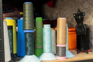 Colorful spools of thread arranged on a shelf in a sewing studio photo
