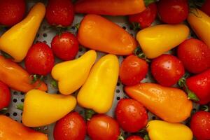 Fresh colorful peppers and tomatoes arranged on a surface photo