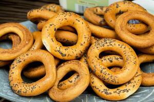 Freshly baked bagels with poppy seeds on a serving platter photo