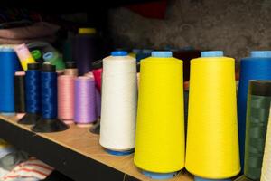 Colorful spools of thread arranged neatly on a shelf in a textile workshop photo
