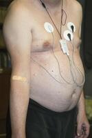 Man undergoing electrocardiogram monitoring in a medical setting photo