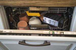 Dishwasher loaded with utensils and cookware for cleaning photo