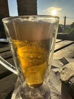 Refreshing beverage under the warm sunset glow in a tranquil setting photo