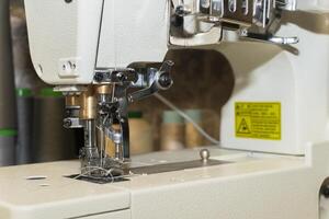 Close-up view of sewing machine with thread in workshop setting photo