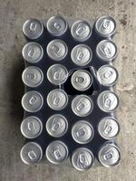 Collection of soda cans arranged in a uniform pattern on a surface photo