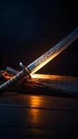 Sword on a wooden table with a light shining on it photo