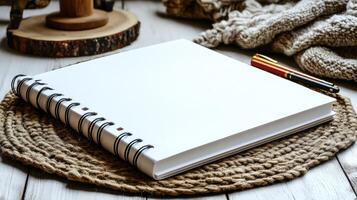 A blank notebook waits on a rustic table, inviting creativity amidst warm, cozy surroundings photo