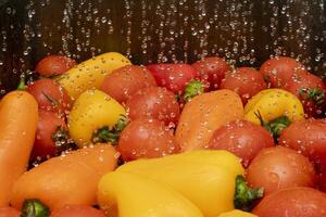 Fresh vegetables being washed in clear water with bubbles photo