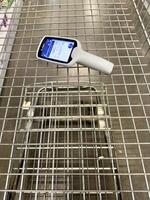 Shopping cart with handheld scanner in a store during a busy day photo