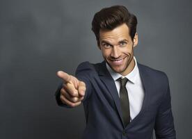 A smiling businessman in a suit points directly at the viewer photo