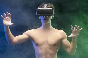 Young boy with bare torso wearing VR glasses, playing online game. Online technology concept photo