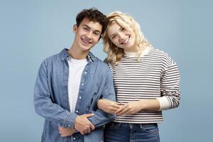 Smiling, happy couple, positive girl and boy hugging, together, posing isolated on blue background photo