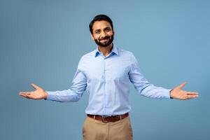 Smiling, positive, handsome Indian bearded man showing hands, looking at camera photo