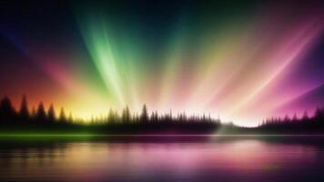 Silhouetted trees against a vibrant, colorful sky with a reflection in a still lake. photo