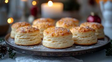 Warm and fluffy biscuits are beautifully arranged on a rustic tray, surrounded by soft candlelight and festive decorations, creating a cozy atmosphere perfect for sharing. photo