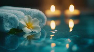 Soft towels are neatly arranged beside a serene pool, accompanied by flickering candles casting a warm glow. photo