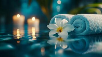 Soft towels are neatly arranged beside glowing candles in a tranquil space. A single white flower rests on the towels, creating a calming atmosphere ideal for multisensory aromatherapy sessions. photo