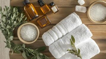 A collection of eco-friendly beauty products is arranged on a wooden surface, featuring amber bottles, salt, and fresh herbs. Soft towels add a touch of comfort to the serene setup. photo