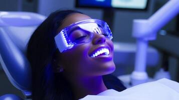 A patient relaxes in a state-of-the-art dental clinic while undergoing a laser teeth whitening procedure. The bright lighting and advanced equipment create a professional atmosphere. photo