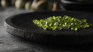 A collection of sparkling green gemstones rests on a textured stone surface, illuminated by soft light. The setting conveys a serene and earthy atmosphere, highlighting the gemstones natural beauty. photo