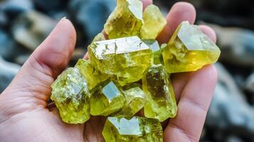 Hand holding a cluster of sparkling yellow gemstones reflecting sunlight, showcasing their unique shapes and translucent qualities. photo