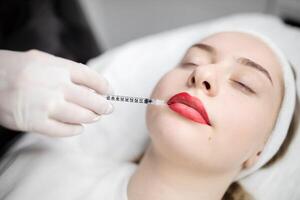 In a beauty salon, woman undergo permanent makeup procedures, focusing on enhancing their lips. The session includes expert application techniques for long-lasting results. photo