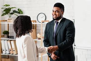 Happy HR manager shaking hands with millennial applicant at job interview at company office photo