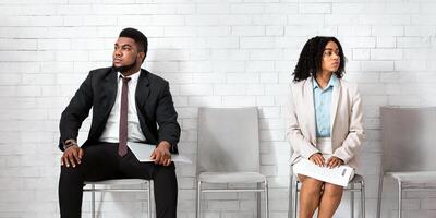 Black man and woman in formal wear looking in opposite directions, feeling competitive while waiting for job interview at office lobby. Vacancy fair, staff recruitment concept photo