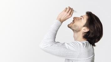 Dry and pain in eyes. Guy dripping eye drops, profile photo