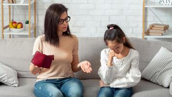 Upset mother and her daughter with empty wallet and heap of unpaid bills having financial problems at home. Parent and child suffering from financial crisis during coronavirus epidemic photo