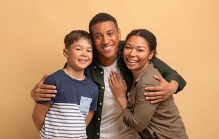 A loving African American family poses together with smiles. The father stands with his wife, while their teenage son embraces them, creating a warm atmosphere of unity and happiness. photo