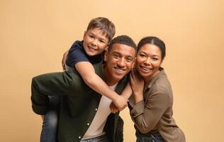 A father, mother, and their teenage son share a moment of happiness and connection. The family poses closely, smiling warmly at the camera, radiating love and unity against a soft backdrop. photo