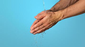 Hygiene during epidemic. Closeup view of man washing hands on blue background, copy space. Panorama photo