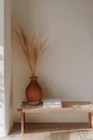 Minimalist interior with clay vase and dried pampas grass on wooden bench photo