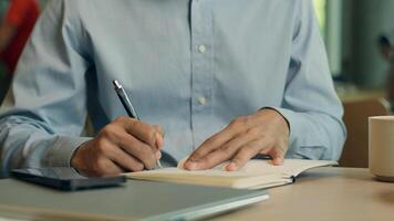 Unrecognizable man businessman writer teacher freelance worker client visitor student write notes business tasks on table cafe male guy study learn writing data in notebook drink coffee in restaurant photo
