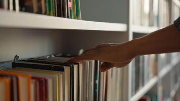 Close up hand African American man choose book bookshelf library bookstore student university unrecognizable reader literature textbooks literary bookworm bookcase education learn buyer shopper books photo